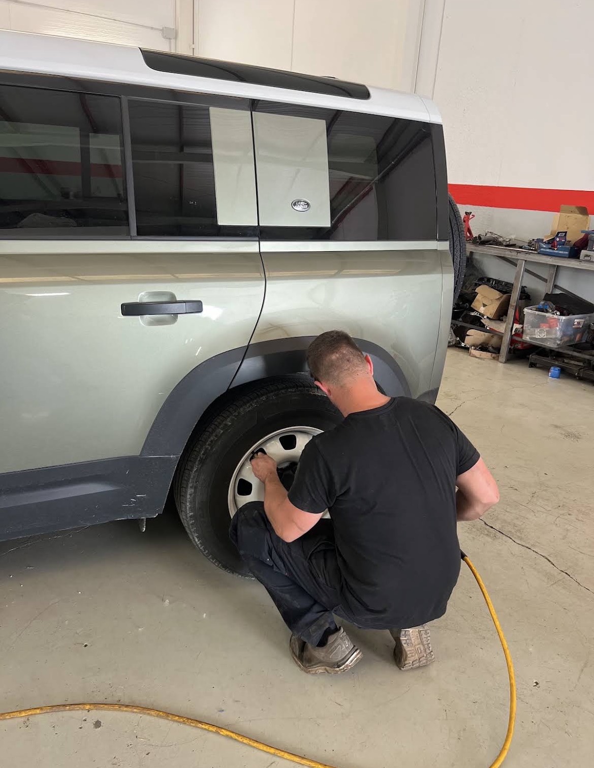 Mechanic working on a Land Rover Defender wheel